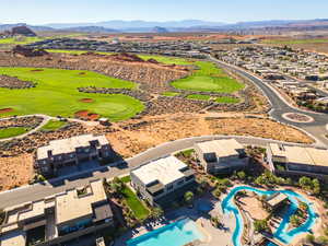 Aerial perspective of suburban area featuring a mountain backdrop and a golf course