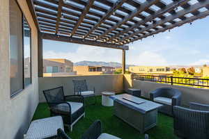 View of balcony with a mountain view, an outdoor living space with a fire pit, a residential view, and a pergola