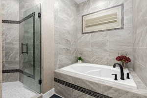 Primary Bathroom with tile walls, a bath, and a stall shower