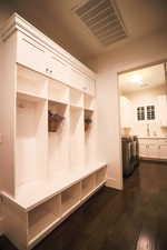 Mudroom with dark wood-style floors and washing machine and dryer