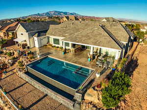 View of swimming pool with a patio area, a fenced backyard, a mountain view, outdoor dining space, and a pool with connected hot tub