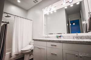 Full bathroom with shower / tub combo with curtain, double vanity, and recessed lighting