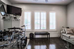 Recreation room with dark wood-style flooring and a ceiling fan