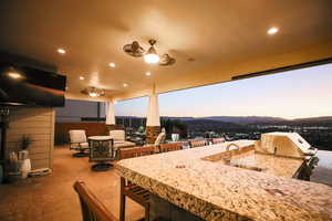 Patio terrace at dusk featuring an outdoor kitchen, a patio, and a mountain view