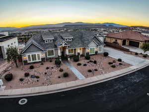 View of front of house with stone siding, driveway, and a mountain view