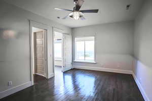 Unfurnished bedroom featuring dark wood-style flooring and ceiling fan