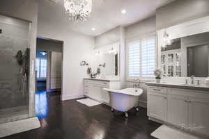 Full bath featuring a chandelier, dark wood-type flooring, a shower stall, and recessed lighting