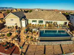Rear view of house featuring a patio, a shingled roof, a mountain view, and a fenced backyard