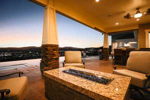 Patio terrace at dusk featuring a fire pit and a patio area