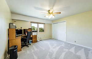 Unfurnished office featuring light carpet and a ceiling fan