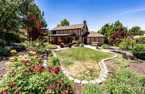 Rear view of property with a fenced backyard, a chimney, a patio area, outdoor lounge area, and a shingled roof