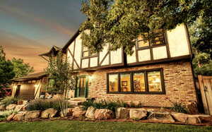 View of front of property with brick siding, stucco siding, and a garage
