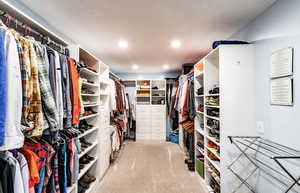 Walk in closet featuring light colored carpet