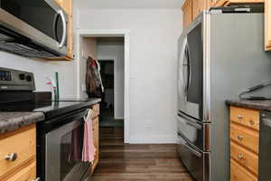 Kitchen featuring appliances with stainless steel finishes and dark wood-style floors