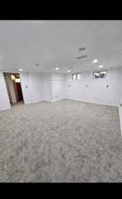 Below grade area featuring dark carpet and baseboards
