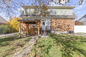 Rear view of property featuring brick siding, a gazebo, and a patio