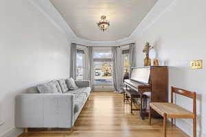 Sitting room with light wood finished floors and ornamental molding