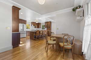 Dining room with light wood-type flooring, recessed lighting, and ornamental molding