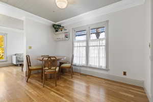 Dining area featuring crown molding and light wood-type flooring