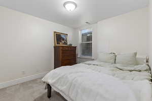 Bedroom with light colored carpet and baseboards
