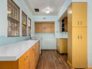 Kitchen with dark wood-style floors, light countertops, backsplash, and white electric stove