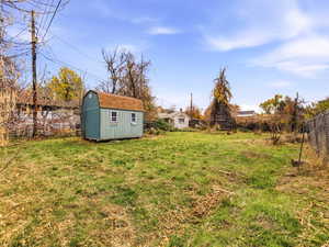 Fenced backyard featuring a shed