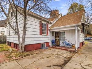View of front facade with a chimney and roof with shingles