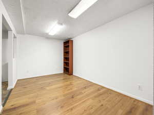 Unfurnished room featuring a textured ceiling and light wood-type flooring