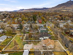 Aerial perspective of suburban area featuring a mountainous background and property parcel outlined