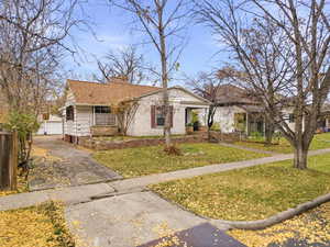 View of front of home with a front lawn, a chimney, a garage, and a porch