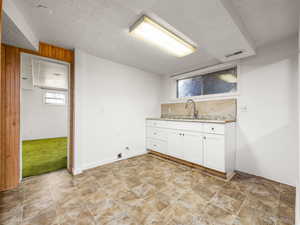 Laundry area with a textured ceiling and a sink