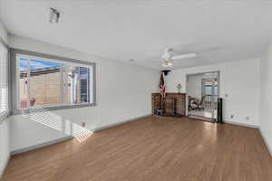 Spare room featuring a textured ceiling, wood finished floors, and ceiling fan