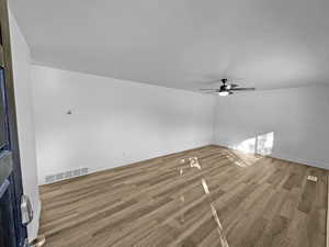 Unfurnished living room featuring wood finished floors and a ceiling fan