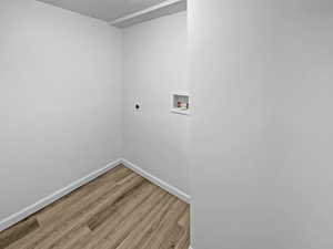 Laundry room featuring wood finished floors, hookup for a washing machine, and hookup for an electric dryer