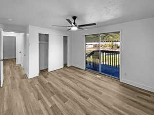 Unfurnished bedroom with light wood-style floors, a textured ceiling, ceiling fan, and access to outside