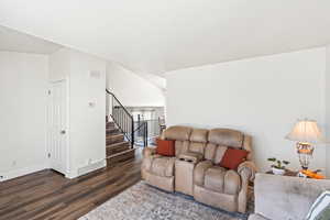 Living room with dark wood finished floors and stairs