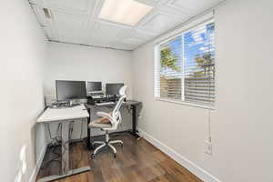 Home office featuring dark wood-type flooring and an ornate ceiling