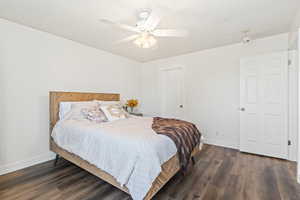 Bedroom with dark wood-type flooring and a ceiling fan