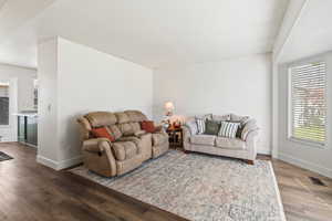 Living area with dark wood-type flooring and a textured ceiling