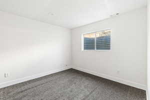 Carpeted spare room with baseboards