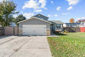 View of front of house with brick siding, concrete driveway, a gate, and a garage