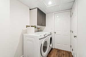 Laundry area featuring dark wood finished floors, washing machine and dryer, an ornate ceiling, cabinet space, and recessed lighting
