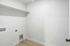 Laundry area with hookup for a washing machine, hookup for an electric dryer, and light wood-style floors