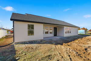 Rear view of house with a patio, a shingled roof, and stucco siding
