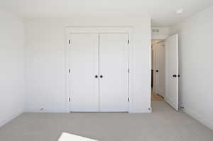 Bedroom 2 with featuring light carpet and a closet