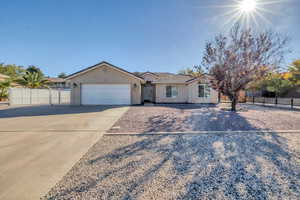 Ranch-style home featuring concrete driveway, a gate, a tile roof, and an attached garage