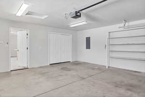 Garage featuring electric panel and a garage door opener