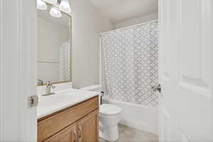 Bathroom with shower / tub combo with curtain, vanity, and light tile patterned floors