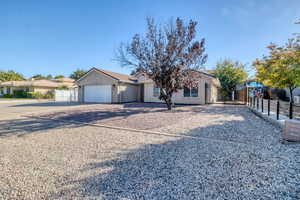 View of front of property with driveway, a garage, and a gate
