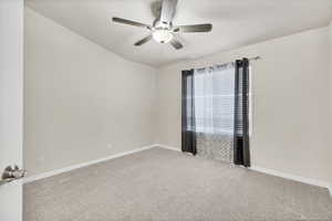 Empty room featuring carpet and a ceiling fan
